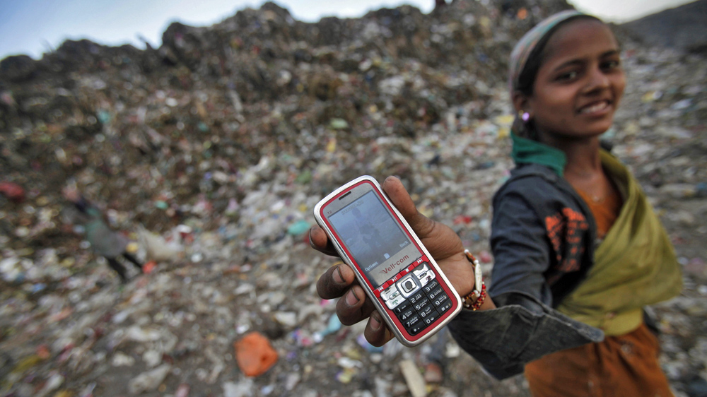 A ragpicker holds her mobile phone to show a picture she took at a dump yard on World Environment Day in New Delhi